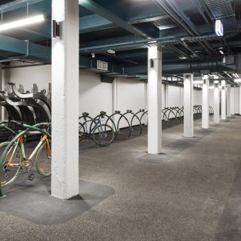 Yarra Falls, Melbourne, featuring a premium secure bicycle storage facility with high-capacity bike parking, floor-mounted bicycle hoops, vertical storage systems, exposed industrial structure, and end-of-trip infrastructure designed to support active commuting, sustainability, and employee wellbeing within a landmark adaptive reuse workplace precinct.