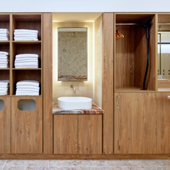 201 Elizabeth Street, Sydney, featuring premium end-of-trip facilities with bespoke walnut timber joinery, luxury grooming stations, integrated towel storage, garment hanging and steaming facilities, natural stone benchtops, and wellness-focused amenities designed to support active commuting, workplace wellbeing, and an elevated tenant experience within Sydney CBD.